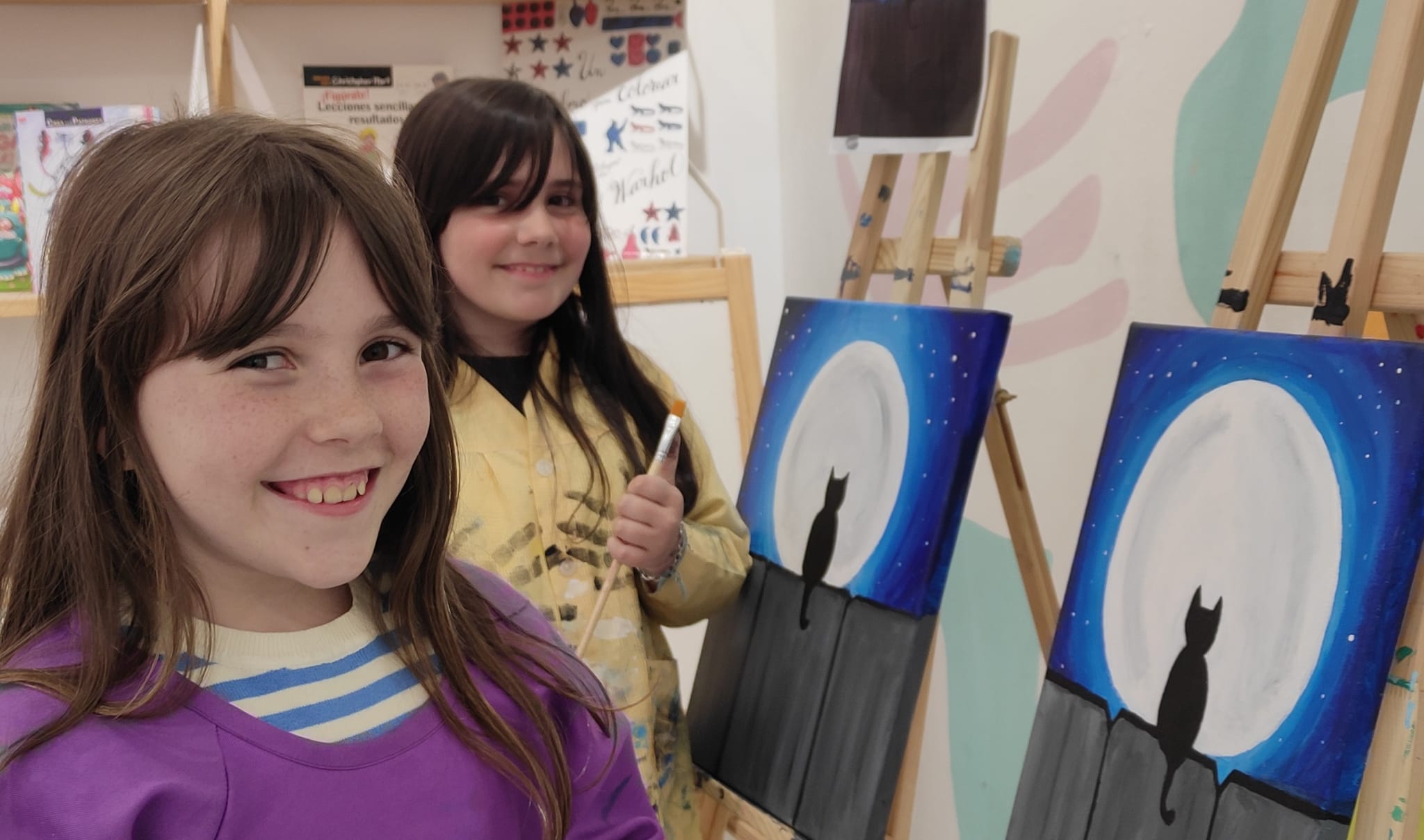 niñas sonriendo con sus cuadros