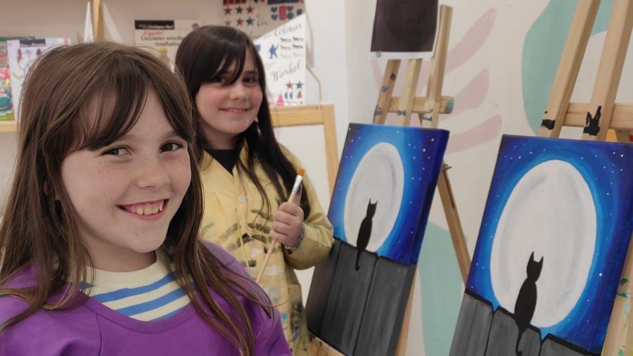 niñas sonriendo con sus cuadros